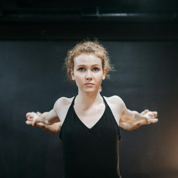 Person stretching outdoors, looking calm and focused.